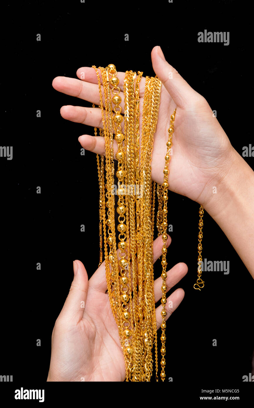 Collo oro laccio ,gioielli in oro nella donna le mani Foto Stock