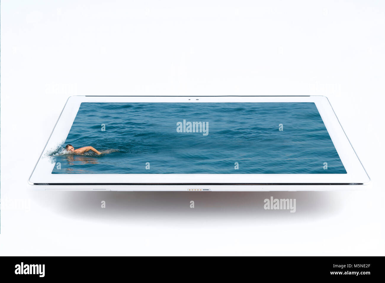 Un nuotatore in acqua che sgorga dal tablet Foto Stock