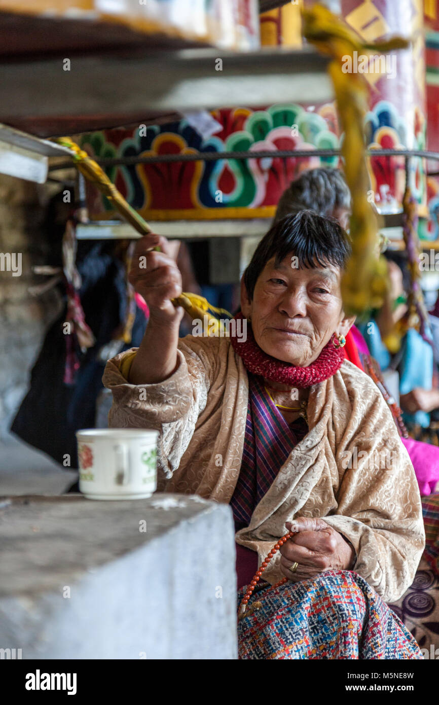 Thimphu, Bhutan. Adoratore ruotando la ruota di preghiera presso il National Memorial Chorten. Foto Stock