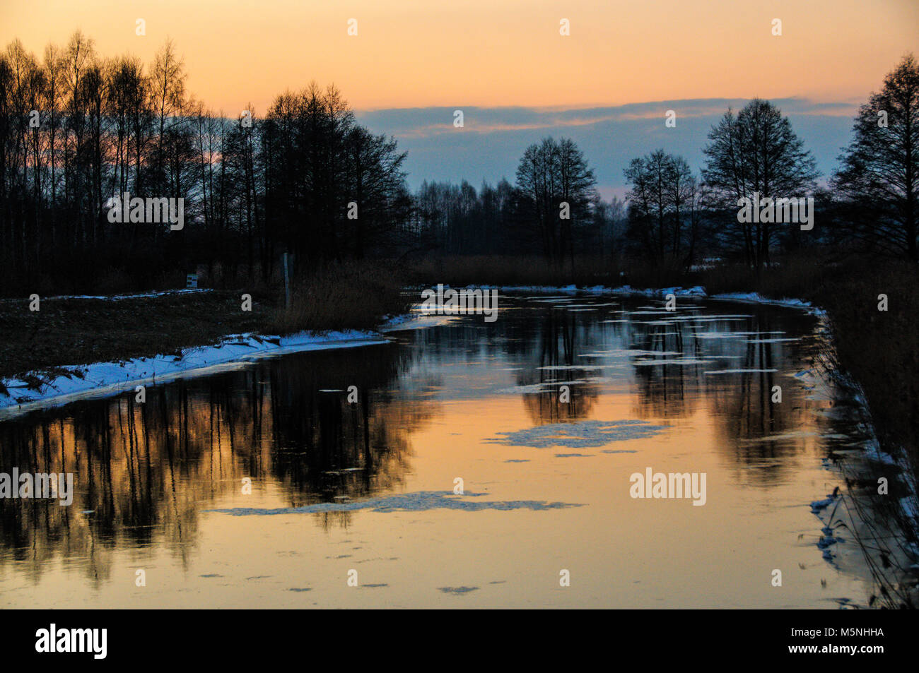 Paesaggio invernale con il fiume, albero tramonto Foto Stock