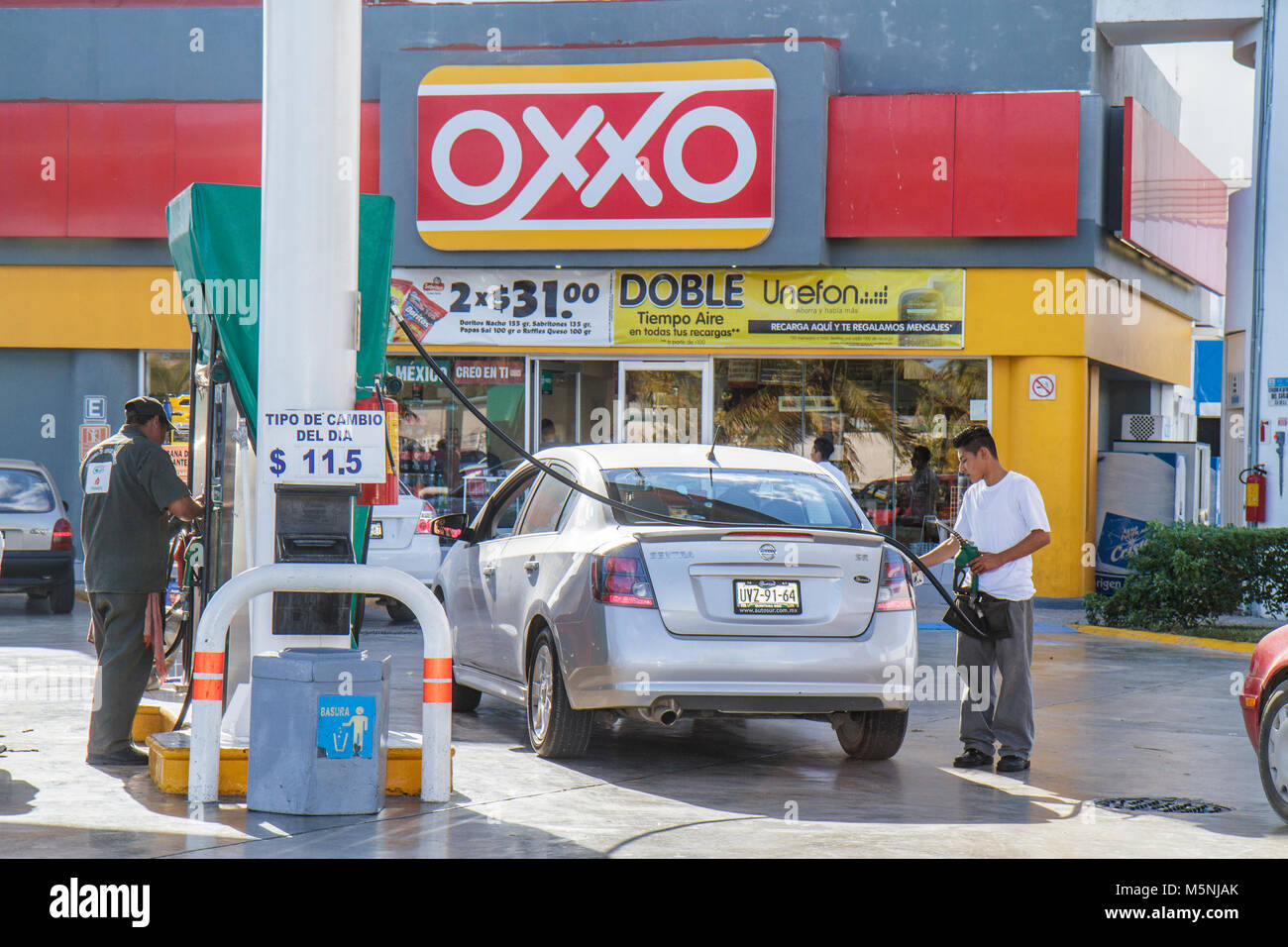 Cancun Messico,Messico,Avenida Tulum,Oxxo,minimarket,benzina,benzina,gas,stazione di rifornimento,pompa,auto,uomo ispanico,tubo,Mex101216040 Foto Stock