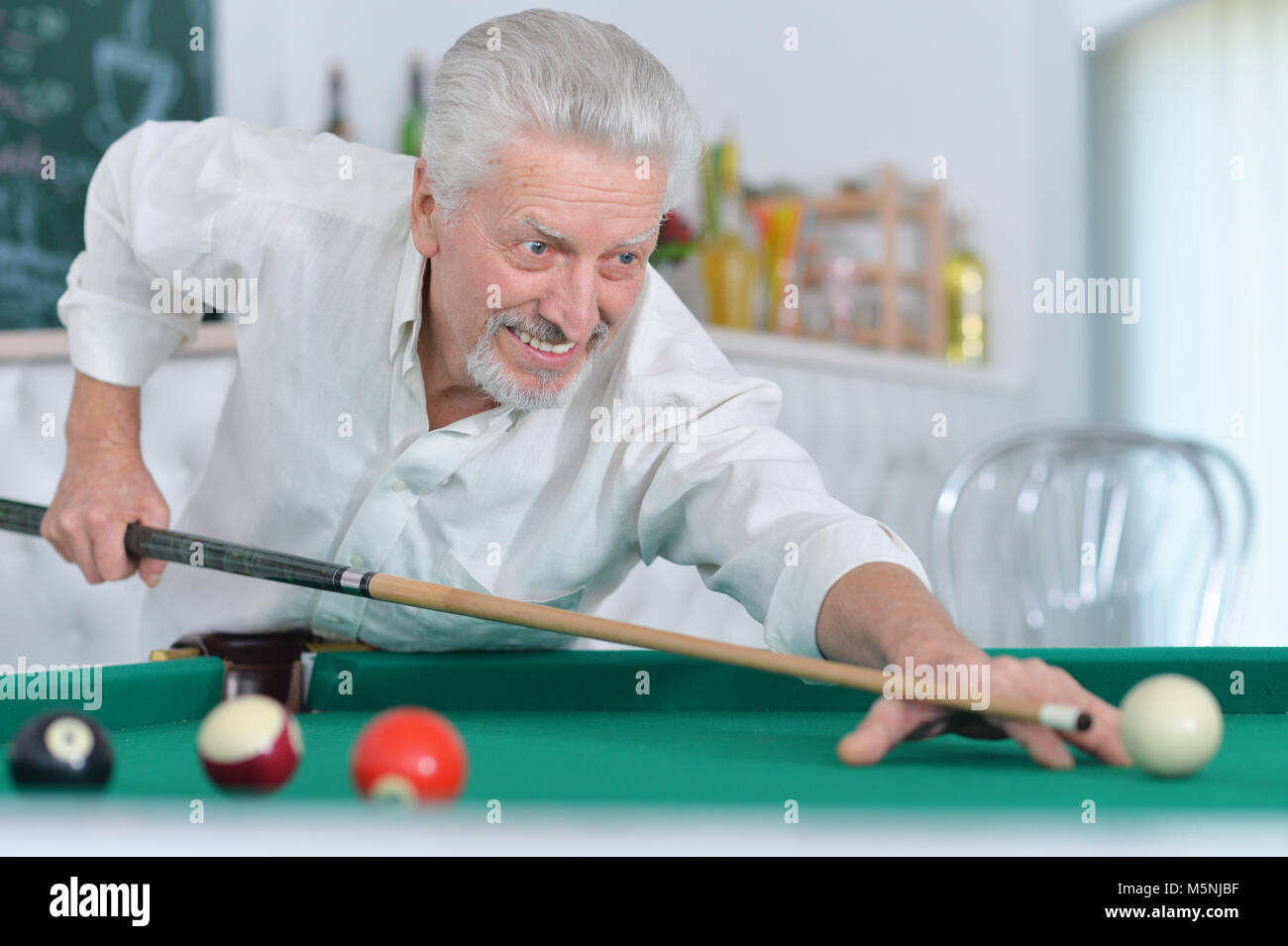 Senior uomo giocando a biliardo Foto Stock