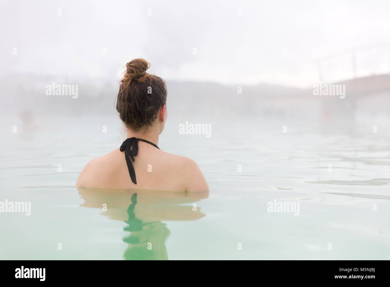 Donna relax nella laguna blu in Islanda Foto Stock