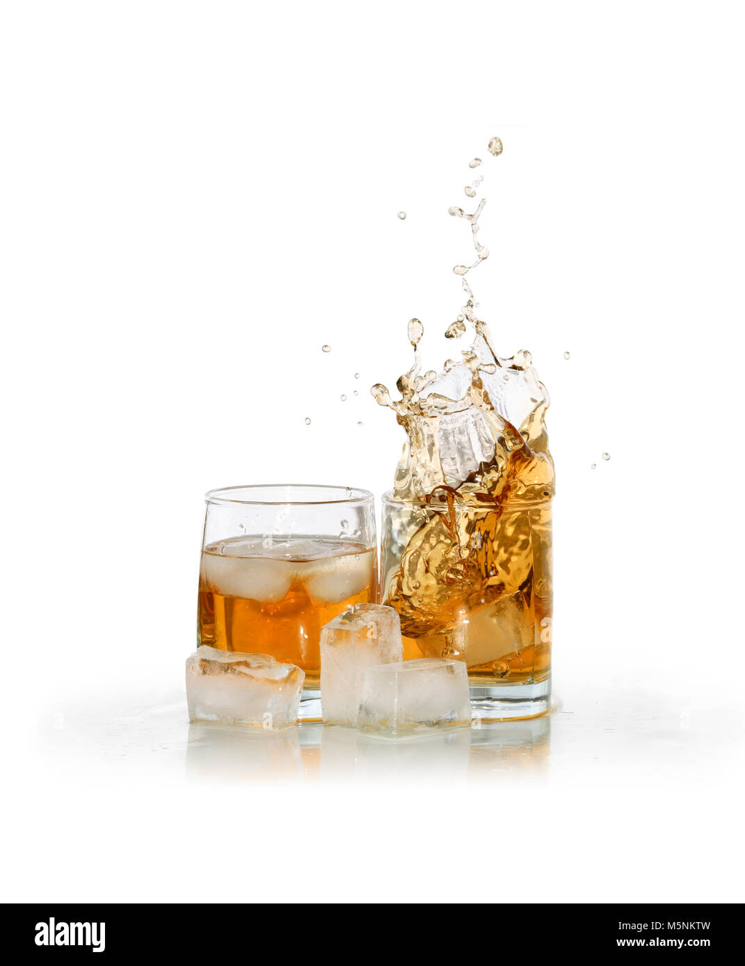 Due bicchieri di schizzi whiskey vicino a cubetti di ghiaccio isolato su sfondo bianco con tracciato di ritaglio Foto Stock