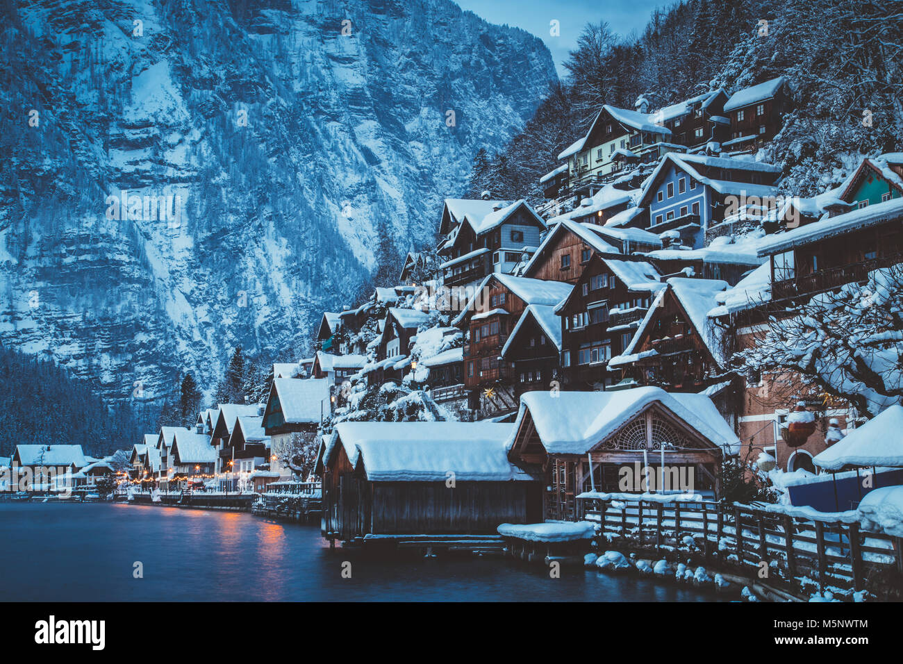 Classic vista da cartolina di tradizionali case di legno nella famosa Hallstatt Lakeside Town nelle Alpi nel crepuscolo mistico durante ore blu all'alba in un beau Foto Stock