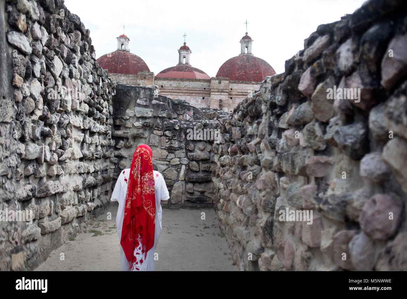Una donna che indossa Oaxaca indigene passeggiate abbigliamento in Mitla sito archeologico di Oaxaca, Messico Foto Stock