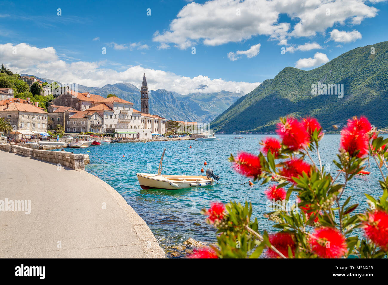 Città storica di Perast situato alla famosa Baia di Kotor in una bella giornata di sole con cielo blu e nuvole in estate, Montenegro, Balcani, Europa Foto Stock