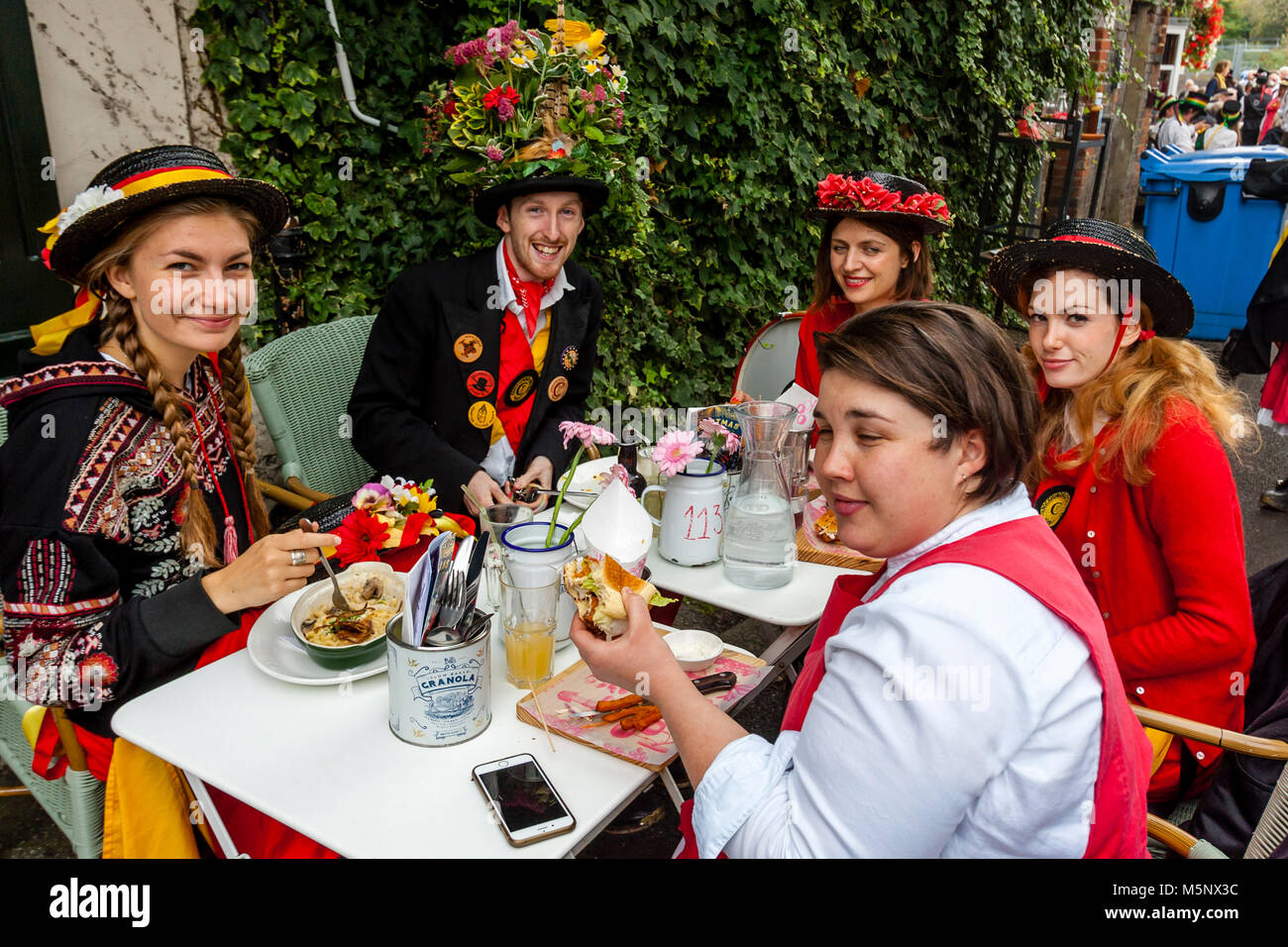 Un gruppo di giovani ballerini di Morris di mangiare il pranzo al Cafè durante l annuale Lewes Folk Festival, Lewes, Sussex, Regno Unito Foto Stock