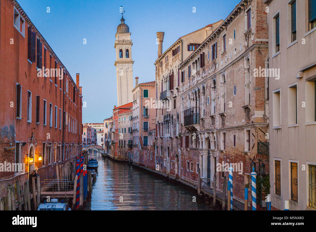 Venezia classica scena cittadina con bel canale e il campanile di una chiesa in background in bella crepuscolo serale al tramonto in estate, Venezia, Italia Foto Stock