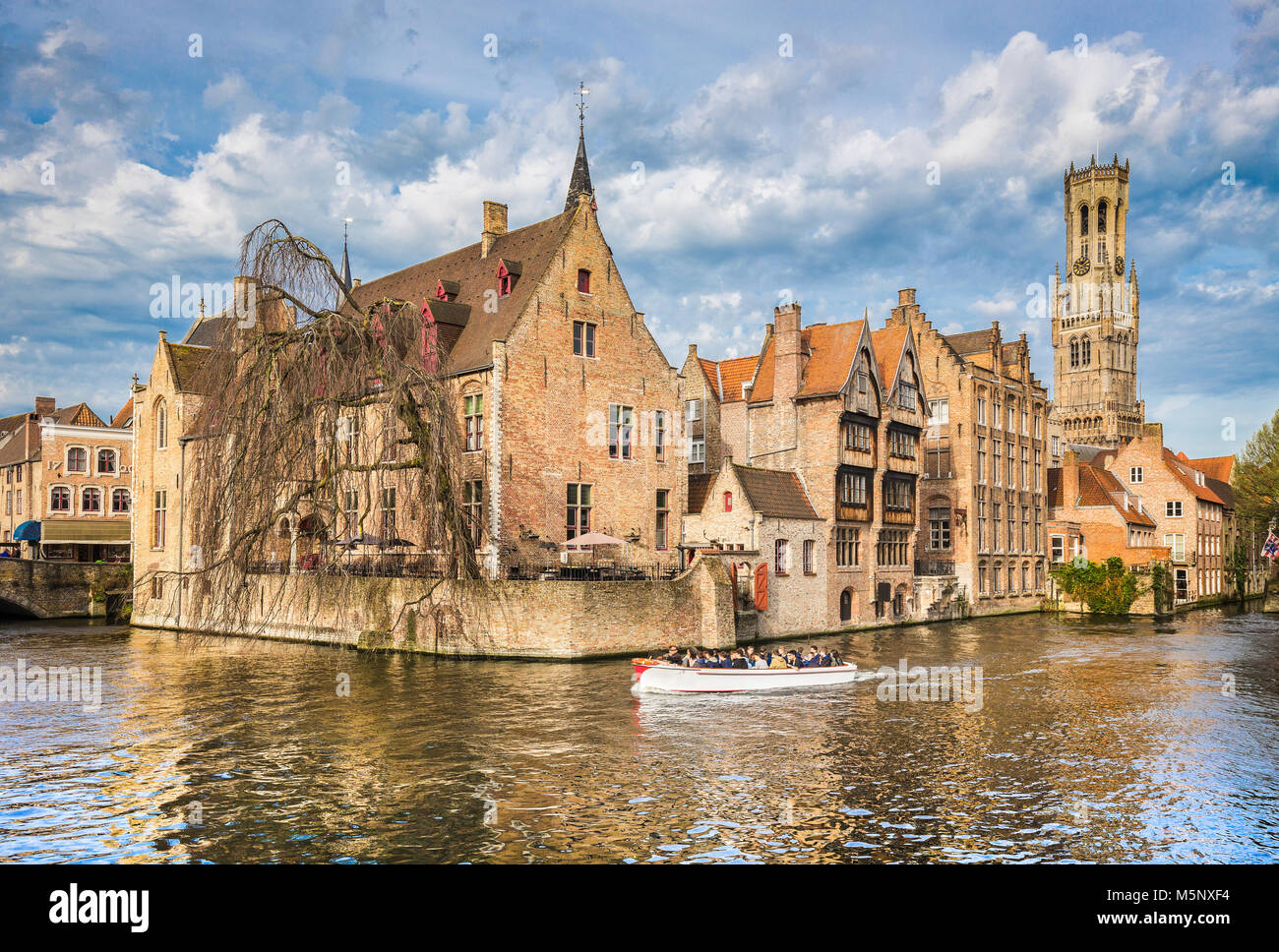 Centro storico di Brugge, a cui spesso viene fatto riferimento come la Venezia del Nord, con turisti facendo un giro in barca in una giornata di sole, le Fiandre, in Belgio Foto Stock