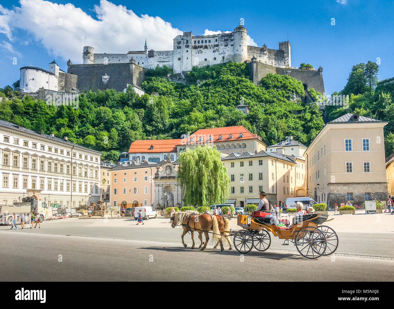 Nel centro storico della città di Salisburgo con tradizionali a cavallo il Fiaker carrello e la famosa fortezza di Hohensalzburg in estate, Austria Foto Stock
