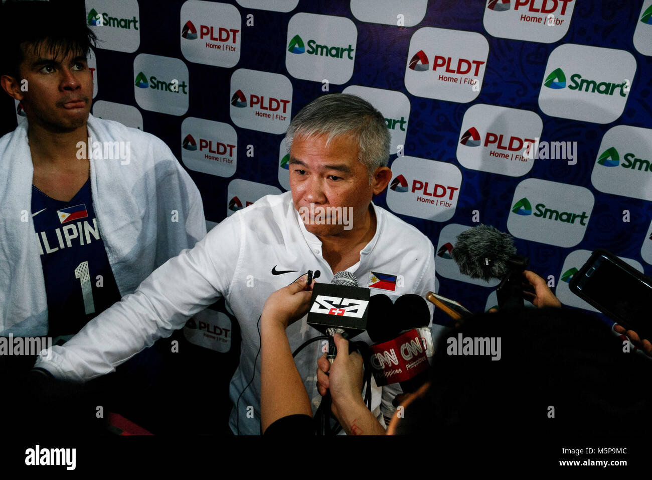 Filippine. Il 25 febbraio, 2018. Chot Reyes (c), Filippina team head coach, essendo intervistato dai media dopo aver vinto il gioco. Il filippino e giapponese della squadra di basket si è incontrato in cemento del Mall of Asia Arena di Pasay City per la FIBA World Cup 2019 qualificatori asiatica. Le Filippine ha conquistato il Giappone, 89-84. Credito: J Gerard Seguia/ZUMA filo/Alamy Live News Foto Stock