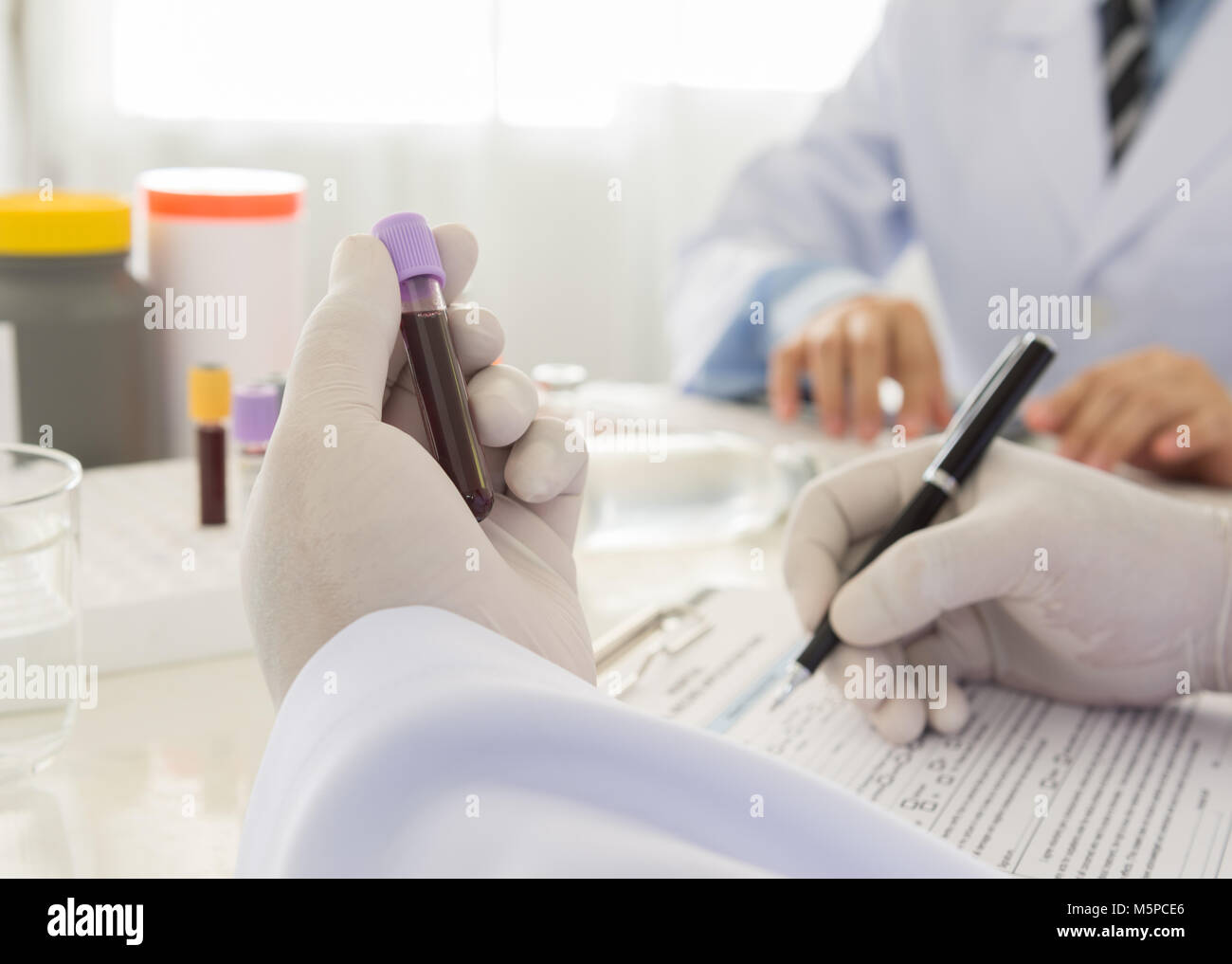Medico tenendo una bottiglia del campione di sangue in laboratorio. scienza e concetto medico Foto Stock