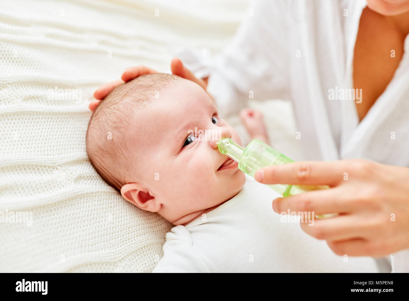 Naso da un neonato viene liberato di muco con l'Aspiratore nasale Foto Stock