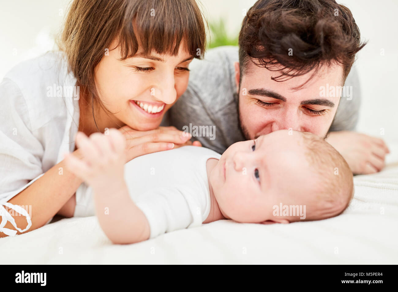 Felici e orgogliosi genitori coccolare con il loro neonato Foto Stock