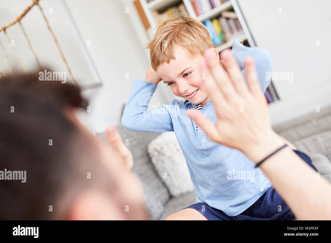 Sorridente ragazzo gioca con il suo padre un gioco per bambini Foto Stock