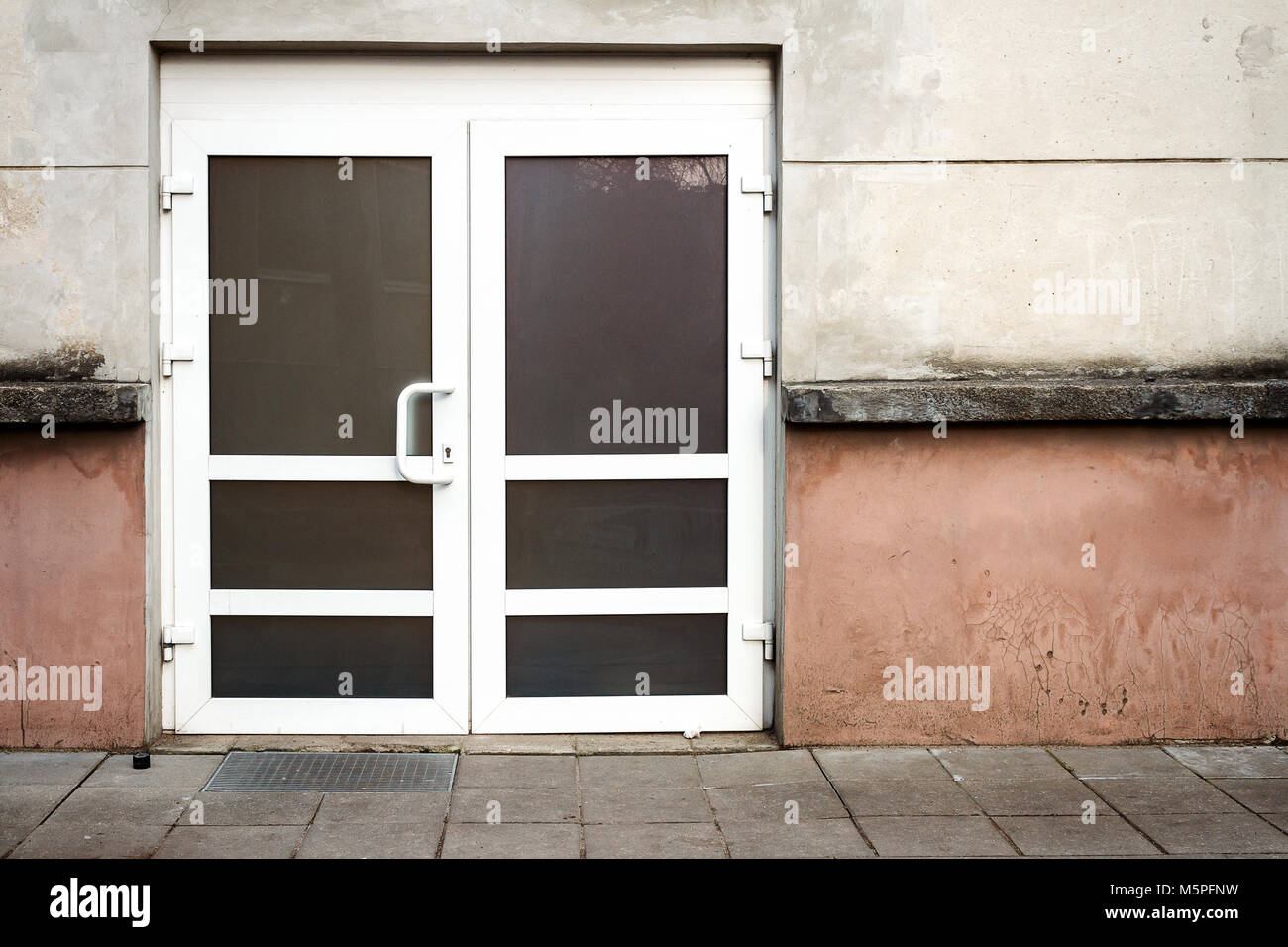 Parete in cemento con copia spazio e porta nuova. Dettagli architettonici sullo sfondo Foto Stock