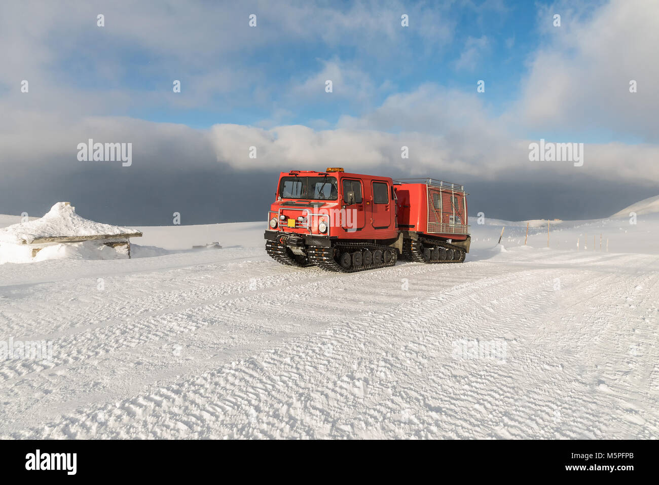 Ratrak rosso gatto delle nevi in montagne invernali un rosso neve tucker coperte di neve in Krkonose Mountain. Rosso su-Veicolo da neve, Foto Stock