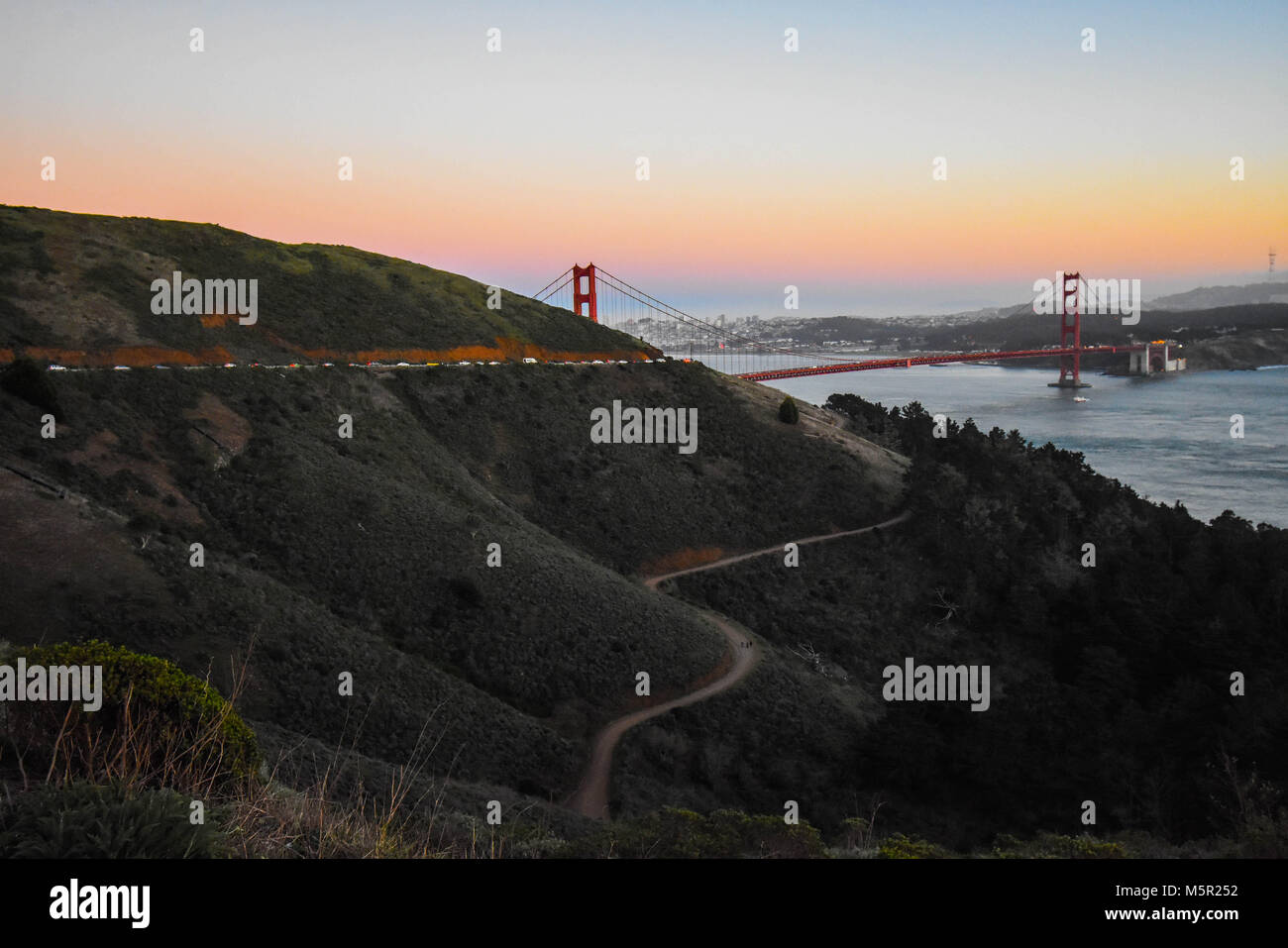 Il sole al tramonto proietta un bagliore sognante su San Francisco e il Golden Gate. Foto Stock