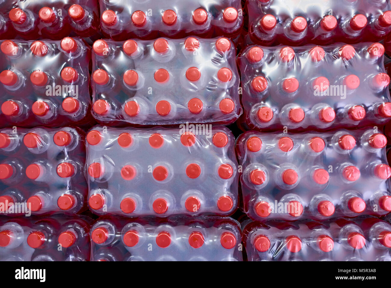 Righe di soft drink bottiglie in plastica avvolgere in piedi nel magazzino della fabbrica moderna, direttamente sopra visualizza Foto Stock