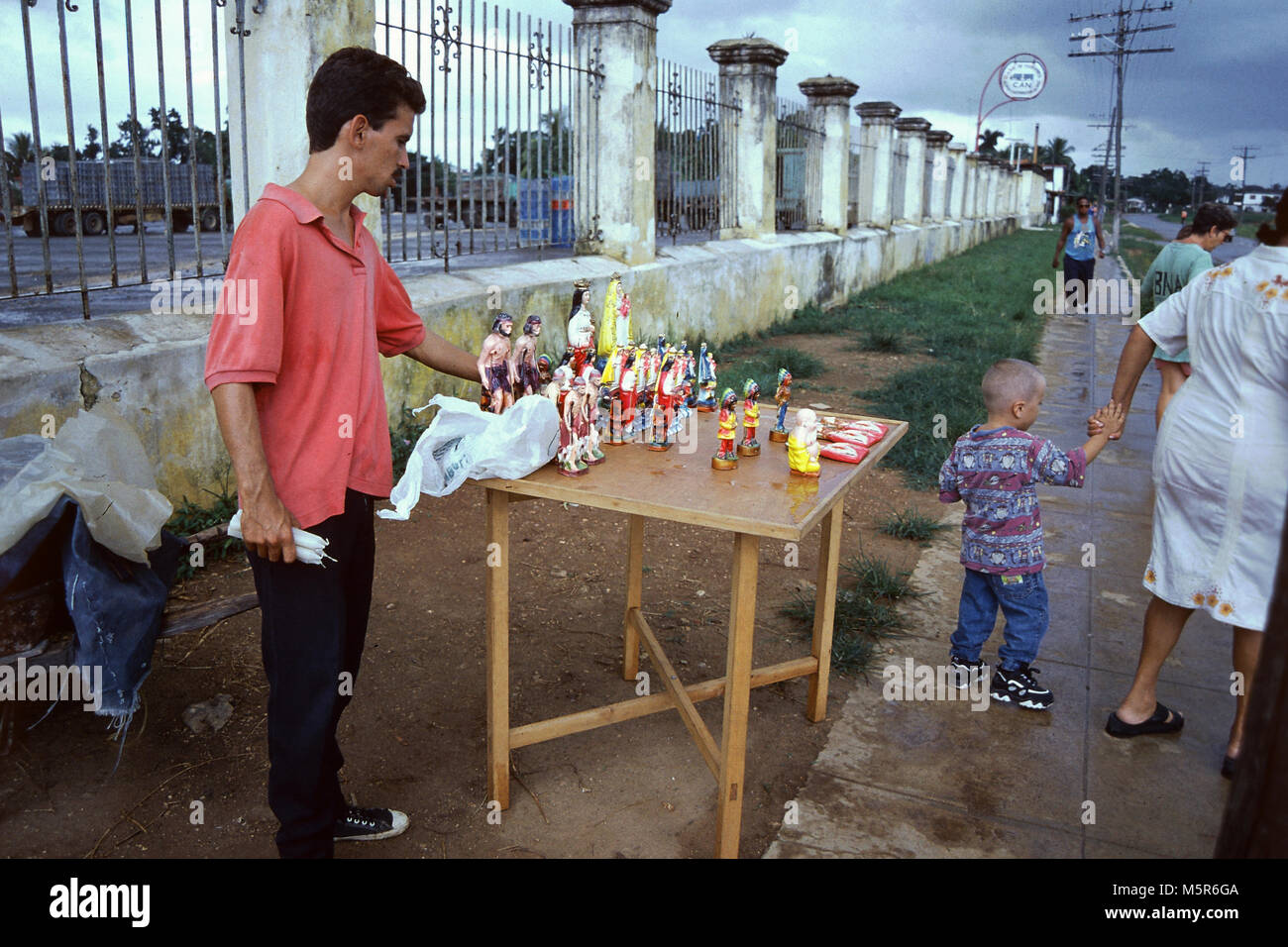 Un venditore ambulante che vende articoli religiosi accanto a San Lazaro chiesa,patrono di guarigione e gli ammalati,presso il villaggio-come l Avana sobborgo di Rincón, Cuba Foto Stock