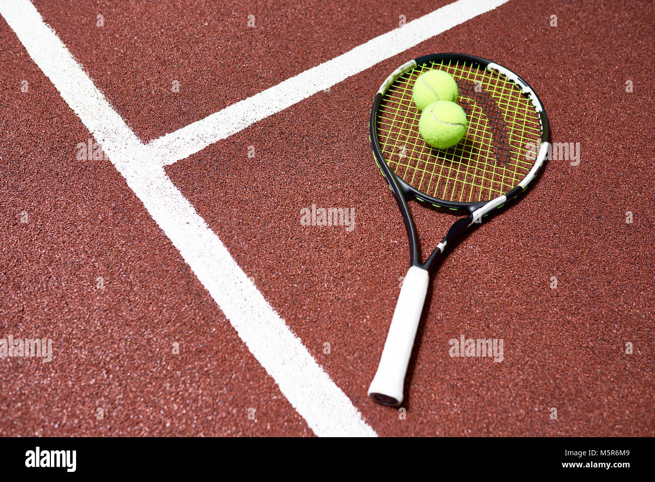 Vista sopra lo sfondo della racchetta da tennis con sfera sdraiato sul pavimento di corte, spazio di copia Foto Stock