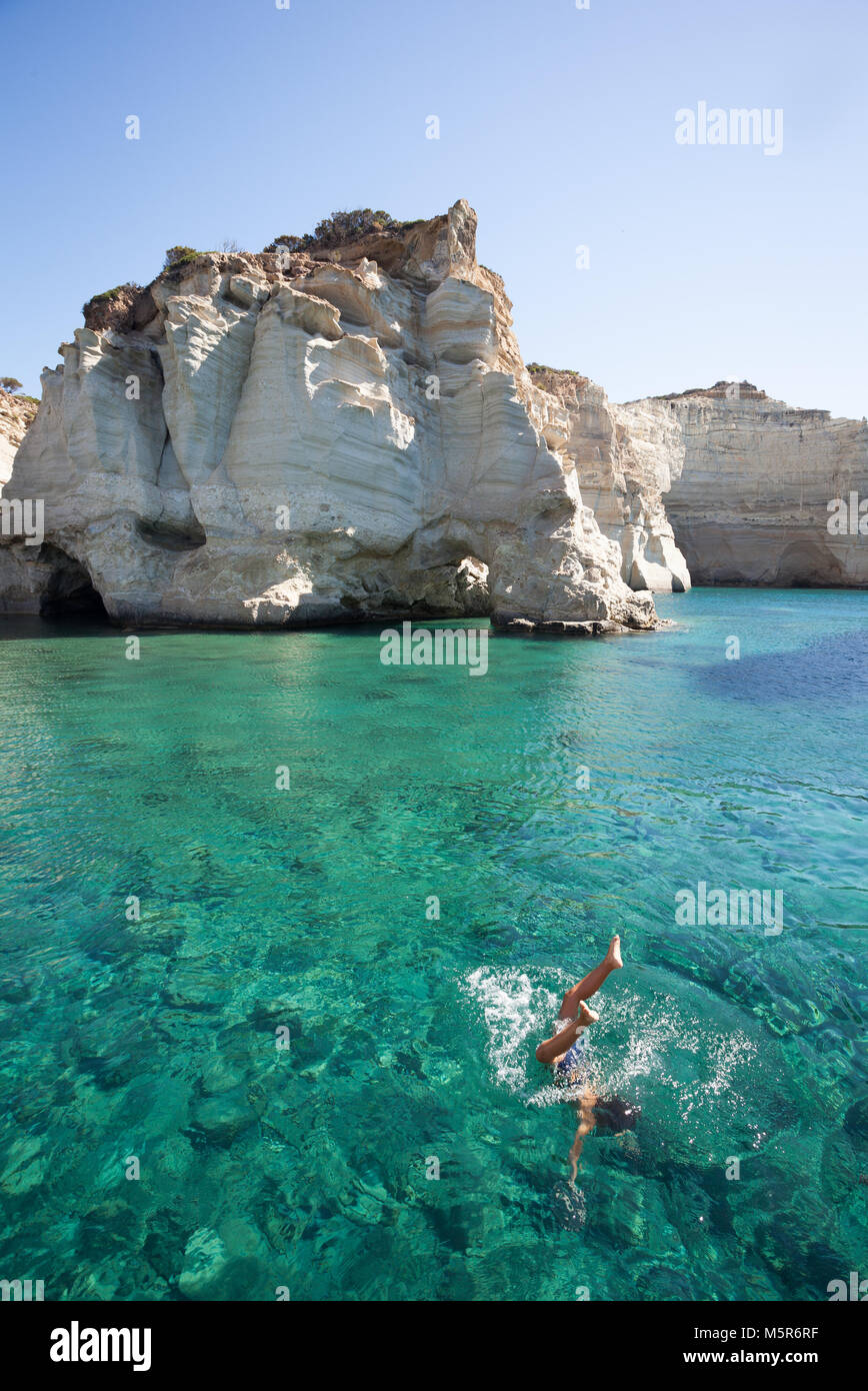 Un ragazzo di immersioni in acque cristalline di isola di Milos, durante il Daily tour in barca, Milos,Grecia Foto Stock