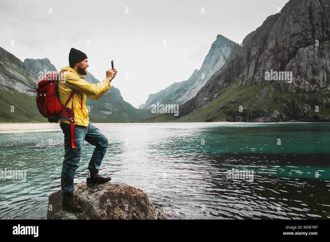 Uomo turistica prendendo selfie tramite smartphone escursioni isole Lofoten beach stile di vita viaggio wanderlust concetto outdoor avventura vacanze estive Foto Stock