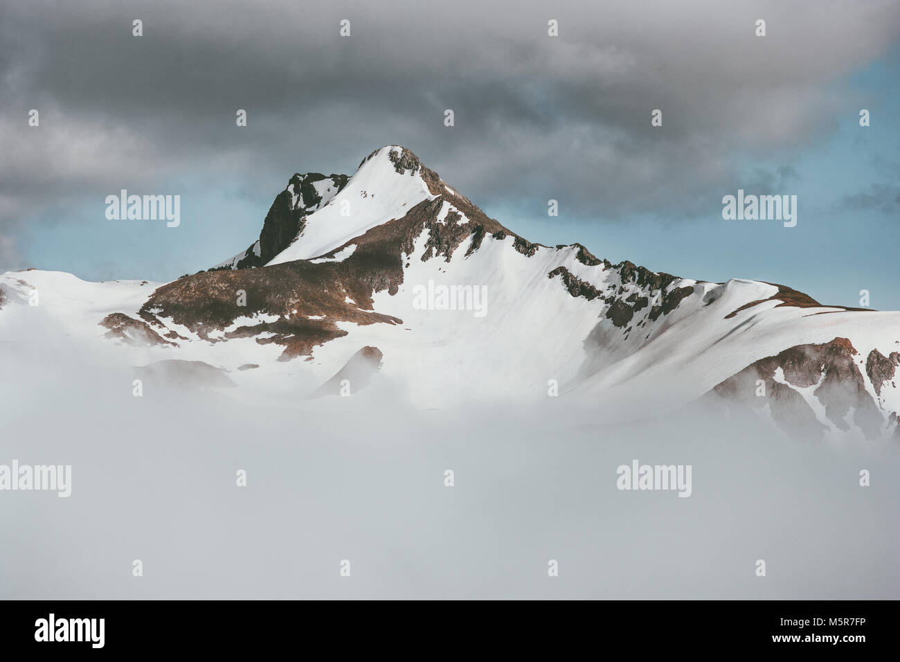Montagne picco innevato in nuvole minima corsa orizzontale di natura selvaggia vista panoramica Foto Stock
