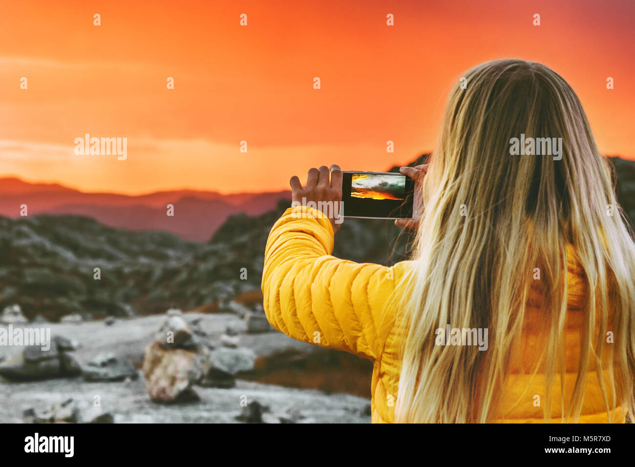Donna traveler prendendo foto tramite smartphone del tramonto paesaggio delle montagne di viaggio e lo stile di vita moderno concetto di tecnologia avventura vacanze outdoor sky Foto Stock