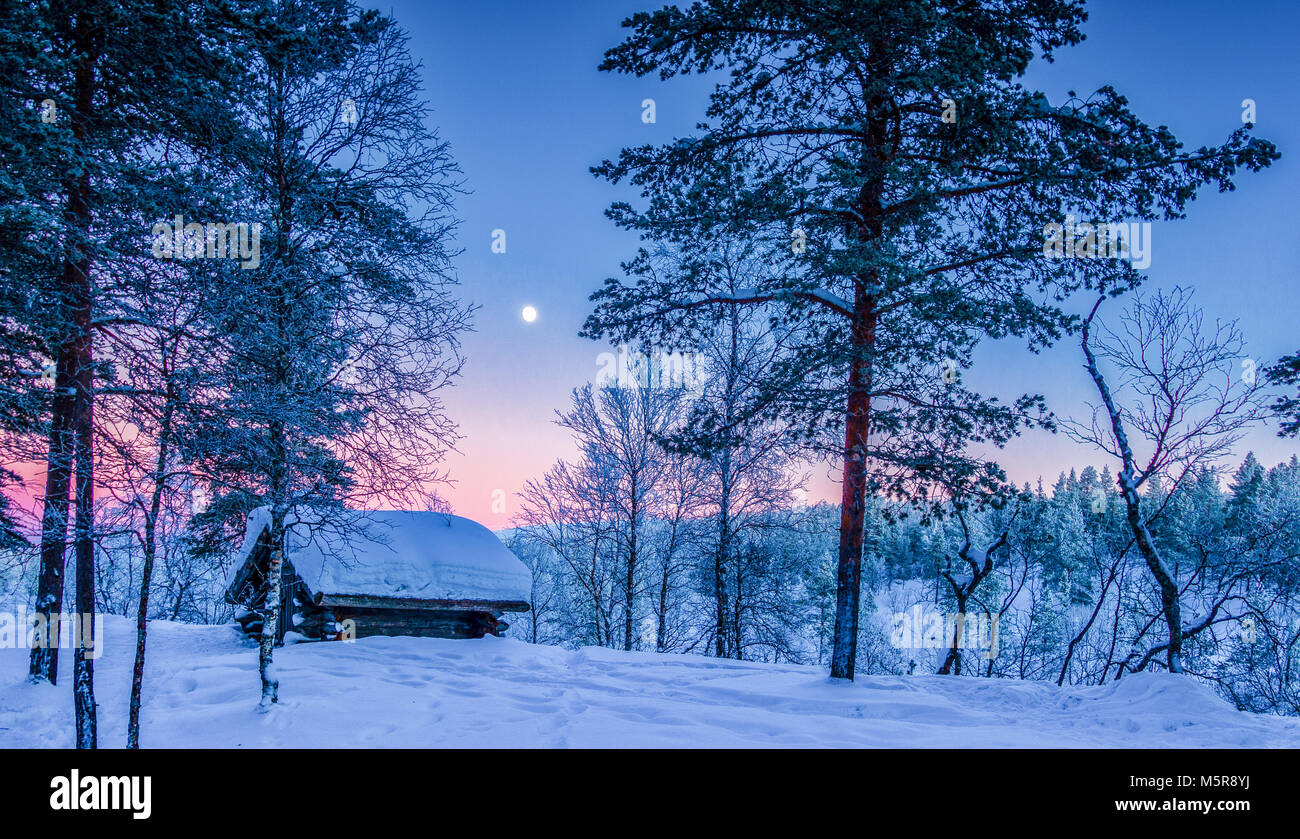 Vista panoramica della splendida winter wonderland paesaggi con tradizionale rifugio di legno in scenic luce della sera al tramonto in Scandinavia, Nord Euro Foto Stock
