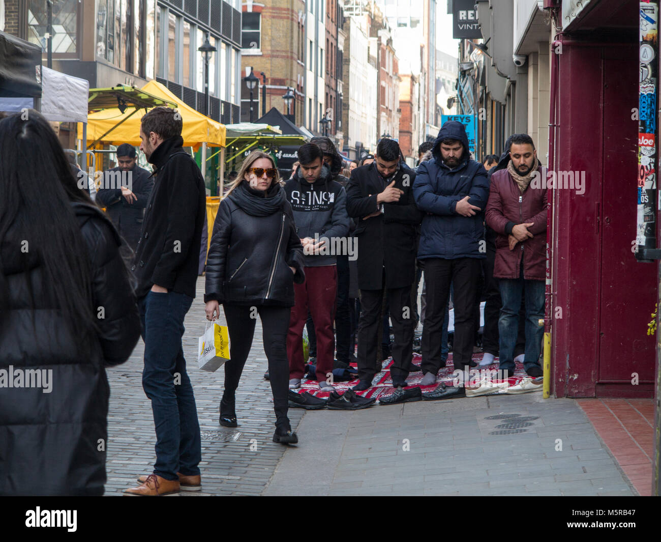 I musulmani tenere la loro preghiera del venerdì in Berwick Street, Soho Foto Stock