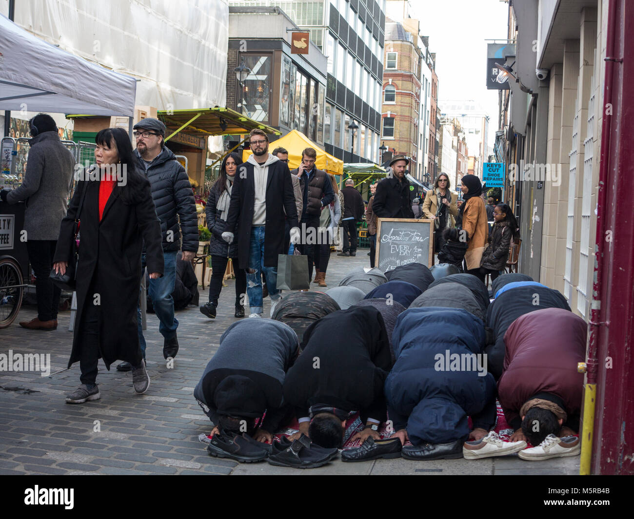 I musulmani tenere la loro preghiera del venerdì in Berwick Street, Soho Foto Stock