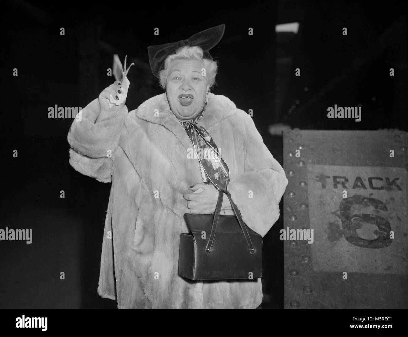 Biglietto in mano, cantante Sophie Tucker onde provenienti da impianti a terra nella stazione di unione a Chicago, ca. 1955. Foto Stock