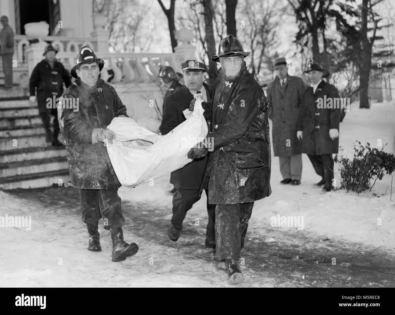 Fireman rimuovere una vittima da una casa di cura il fuoco a Chicago nel 1959. Foto Stock