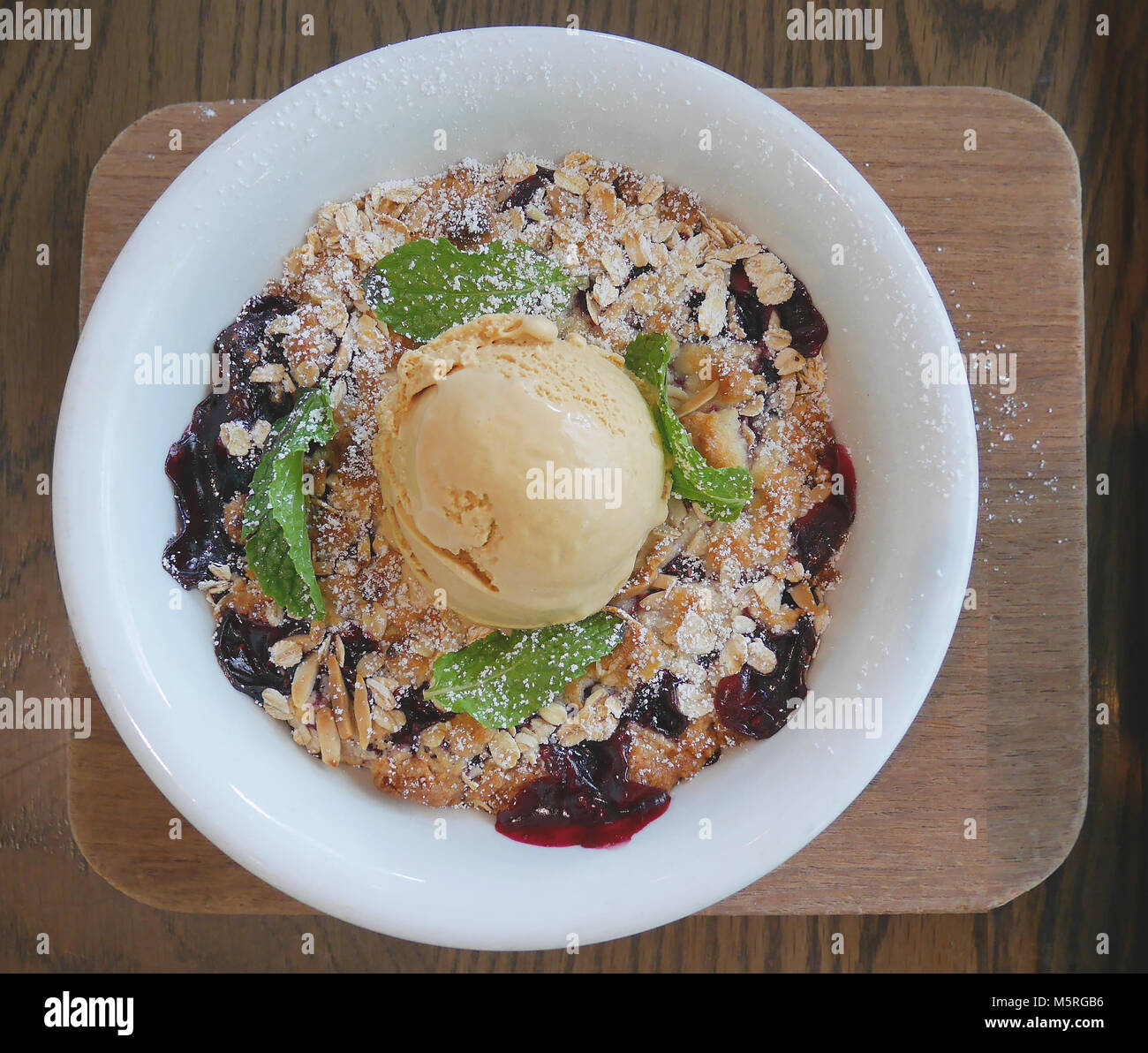 Warm Berry sgretolarsi con avena & Almond Crumble, cardamomo, gelato alla vaniglia Foto Stock