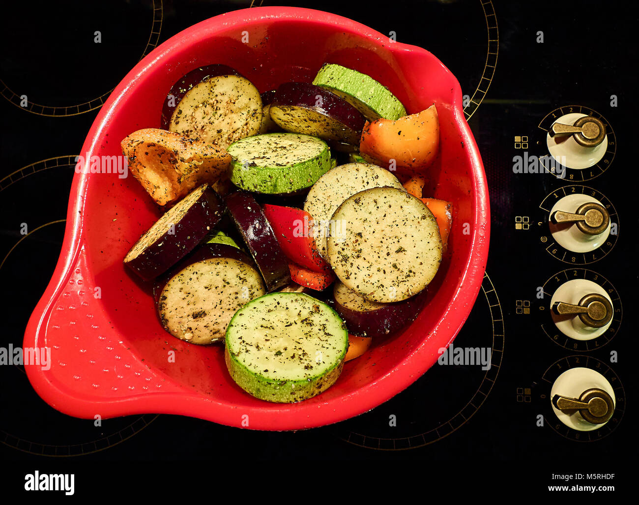 Stufato di verdure nella pentola rosso dall'angolo superiore, sfondo nero Foto Stock