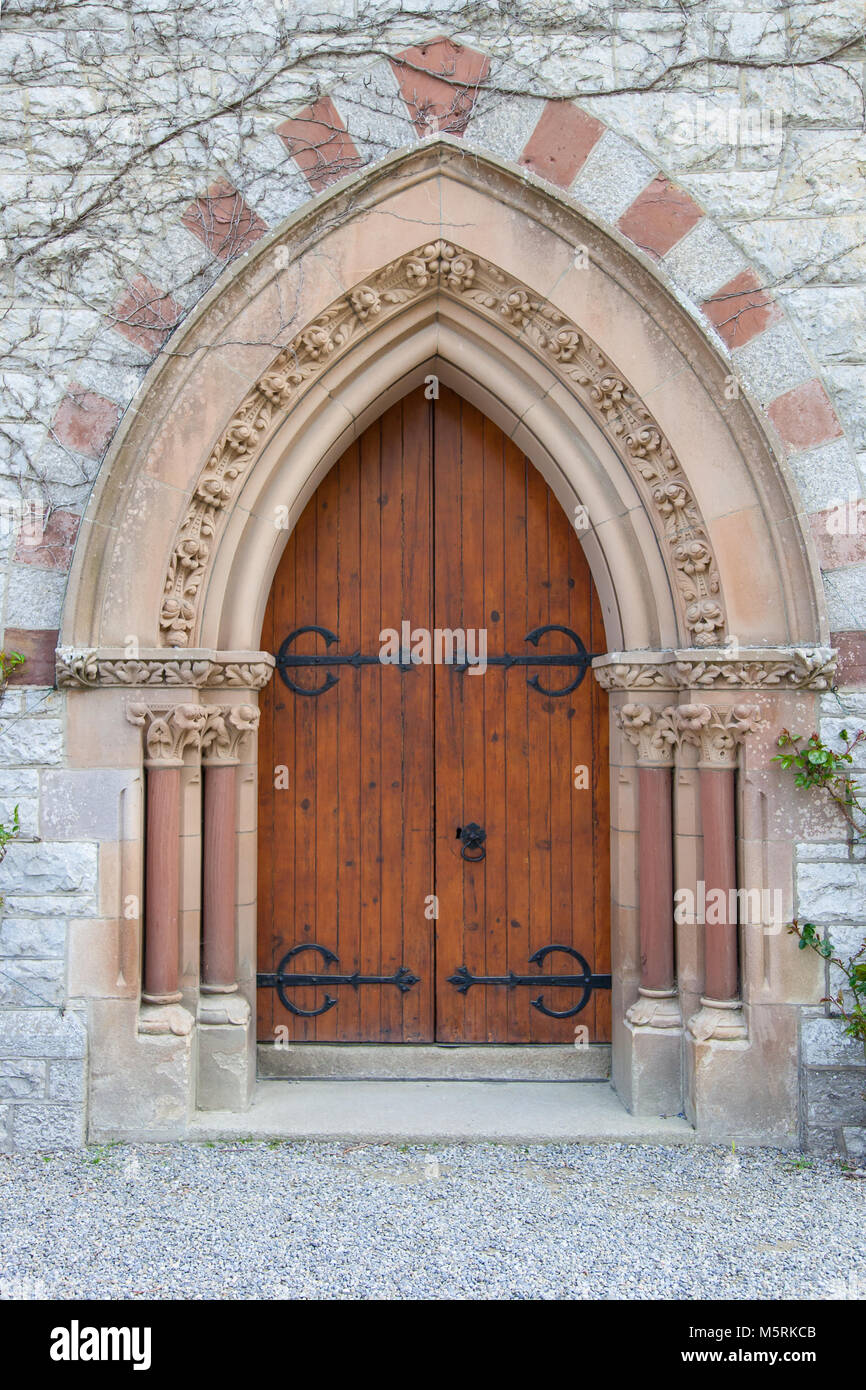 Vecchio ad arco gotico porta della chiesa ornato di colonne di pietra Foto Stock