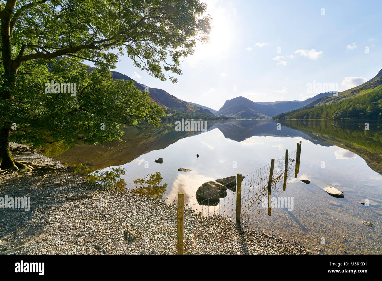 Viste sul lago Buttermere dalla spiaggia ghiaiosa spiaggia nel Lake District inglese su una giornata d'estate, UK. Foto Stock