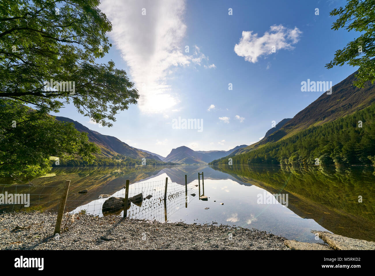 Viste sul lago Buttermere dalla spiaggia ghiaiosa spiaggia nel Lake District inglese su una giornata d'estate, UK. Foto Stock