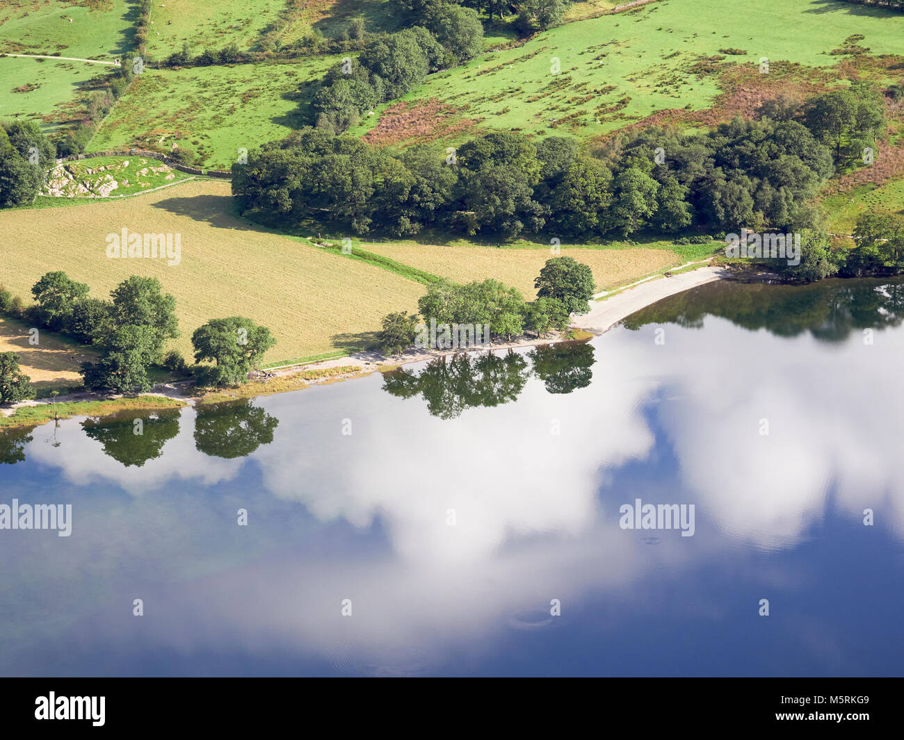 Riflessi di nuvole bianche in un cielo blu sul lago Buttermere nel Lake District inglese, UK. Foto Stock