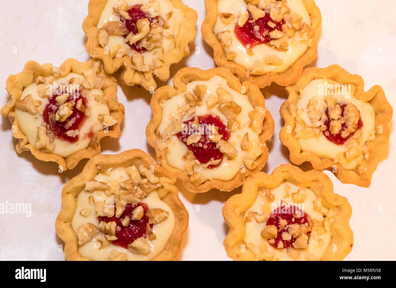 Italia gastronomia basket pasta frolla con crema di colore arancione e una goccia di confettura di fragole Foto Stock