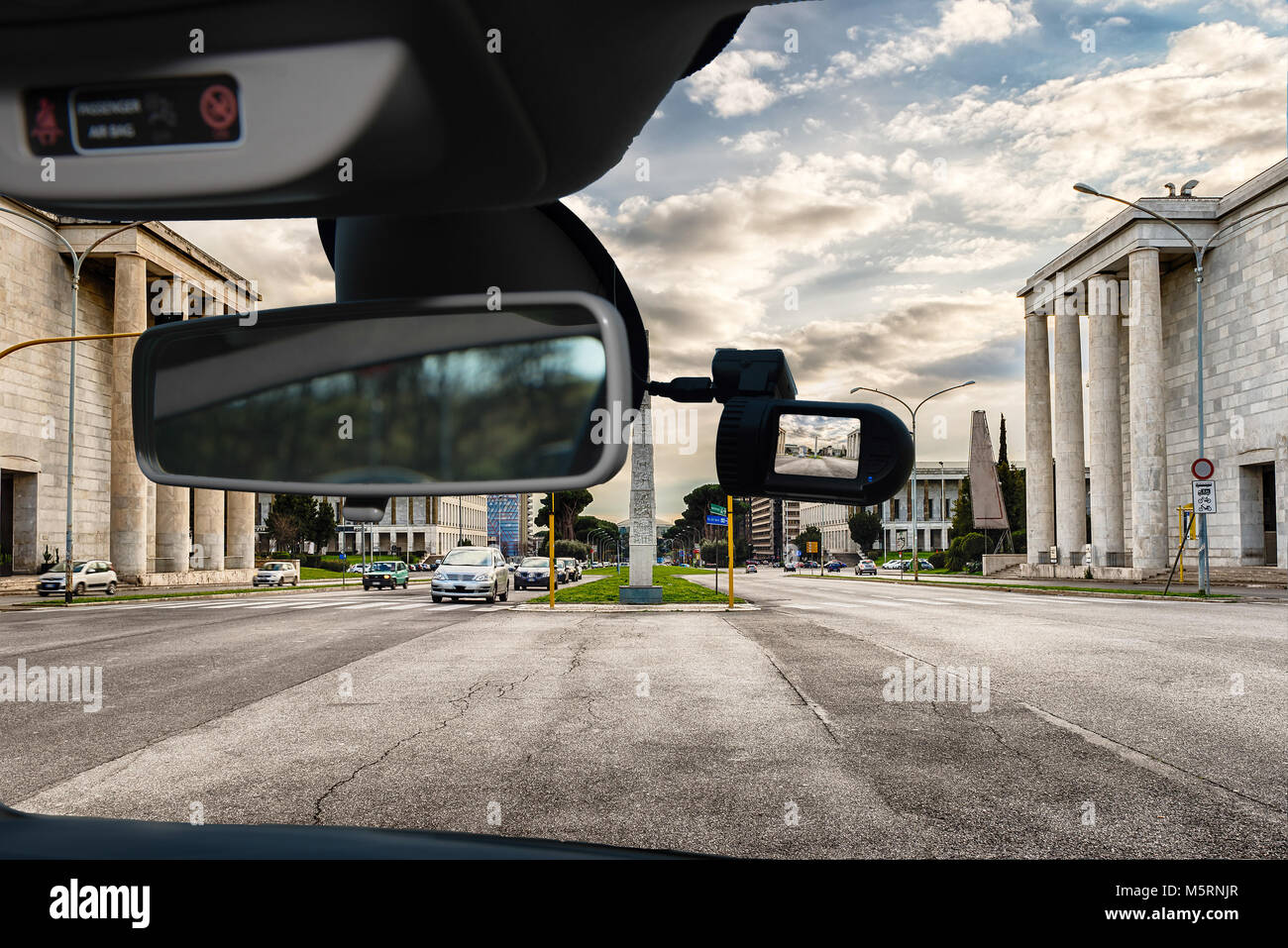 Guardando attraverso un auto dashcam telecamera installata su di un parabrezza con vista della pittoresca architettura neoclassica nel quartiere EUR di Roma, Italia Foto Stock