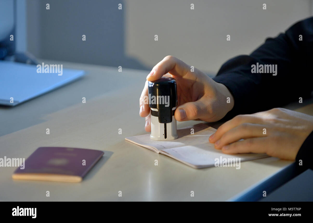 Funzionario doganale della timbratura di un passaporto di viaggio Foto Stock