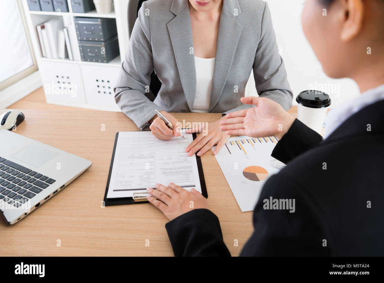 Il dipendente mostra e rispettando la sua proposta per il supervisore boss. Lei fare qualche gesto per rendere il suo punto di vista più chiaro. Il boss finale di concordare e signatur Foto Stock