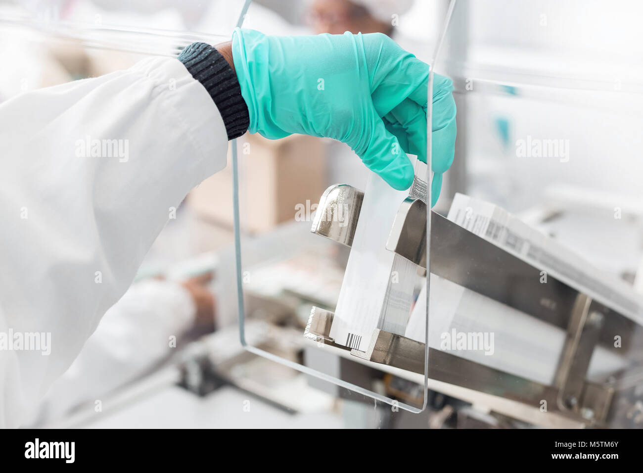 Immissione manuale delle etichette in una etichetta inserimento di macchina. Foto Stock