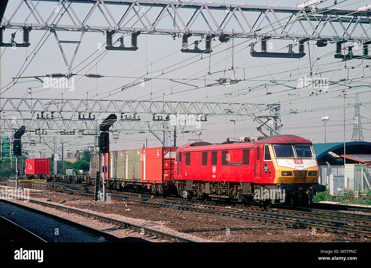 Una classe 90 locomotore elettrico numero 90129 indossando una replica Deutsche Bahn livrea e denominato 'Frachtverbindungen' passa Stratford con un treno di Freightliner il 21 luglio 1994. Foto Stock