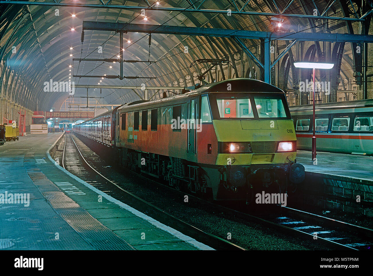 Una classe 90 locomotore elettrico numero 90018 attende di partenza da Londra Kings Cross Station con un viaggio post office treno il 7 gennaio 1994. Foto Stock Una classe 90 locomotore elettrico numero 90018 attende di partenza da Londra Kings Cross Station con un viaggio post office treno il 7 gennaio 1994. Foto Stock