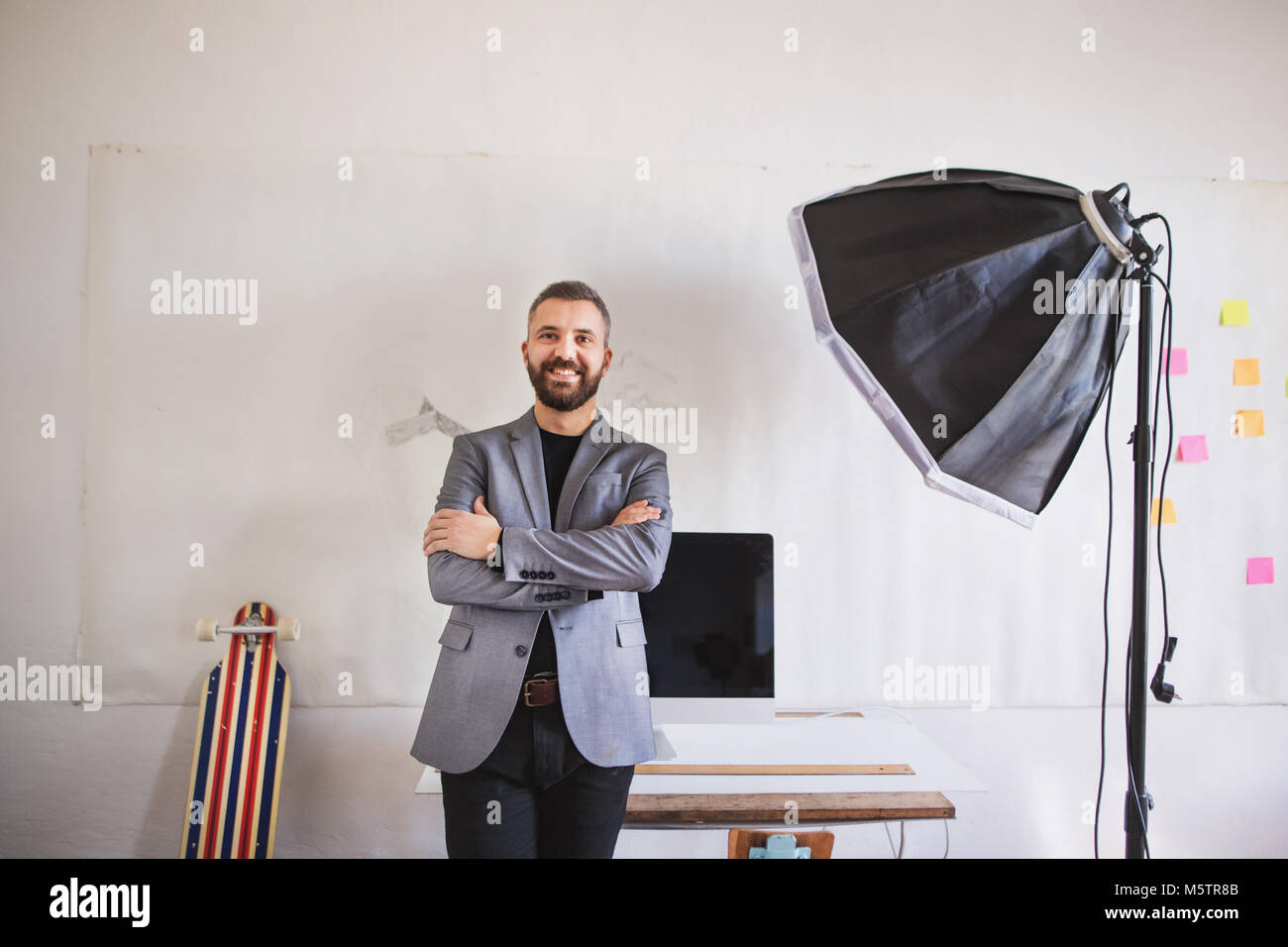 Imprenditore in piedi presso la scrivania nel suo ufficio. Foto Stock