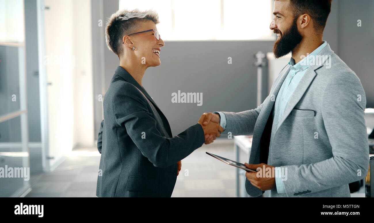 Colleghi di lavoro che stringono le mani dopo la chiusura della trattativa di business Foto Stock